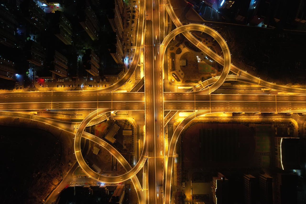 A stunning aerial view of a brightly lit highway interchange in China at nighttime, showcasing intricate patterns.